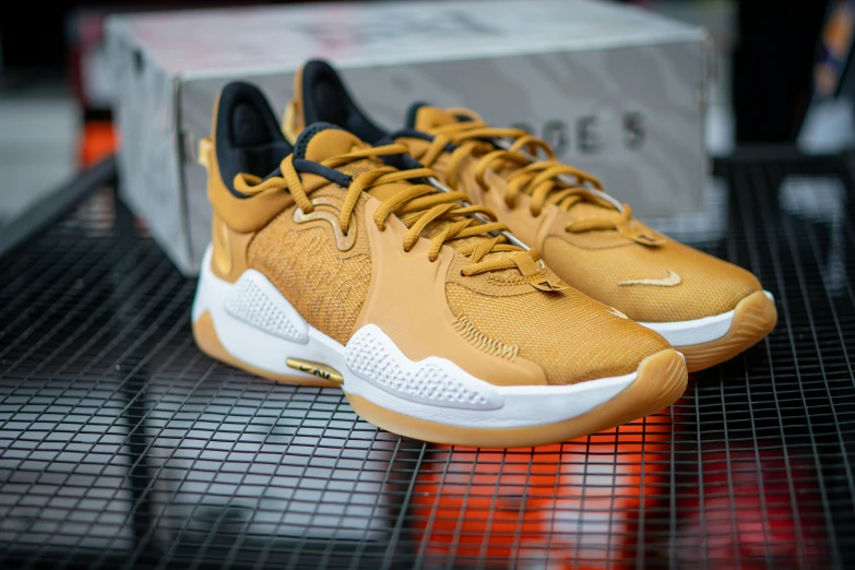 a pair of sneakers sitting on top of a table, gold and yellow notched antlers, caramel, elites, trending dribble