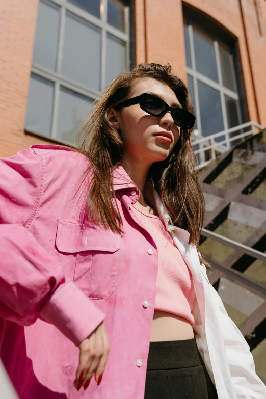 a woman in a pink shirt and black pants, inspired by Elsa Bleda, trending on pexels, cropped shirt with jacket, fashion model in sunglasses, anna nikonova aka newmilky, off - white collection