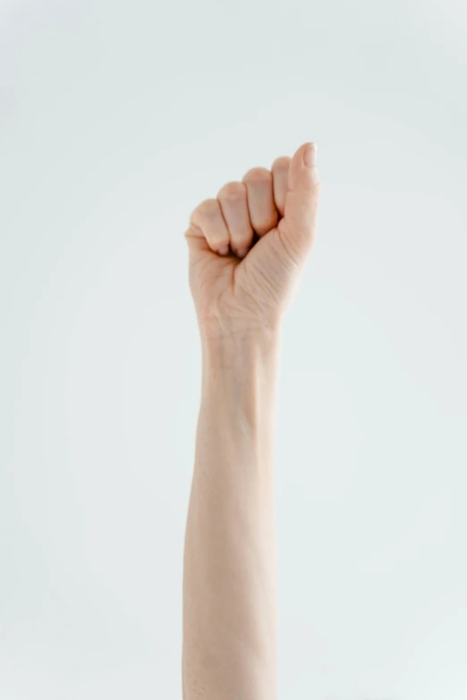 a person raising their arm in the air, trending on pexels, realism, on a pale background, clenched fist, 15081959 21121991 01012000 4k, low detail