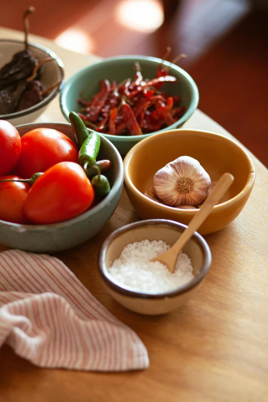 a wooden table topped with bowls of food, flickr, salt shaker, spicy, square, close up image