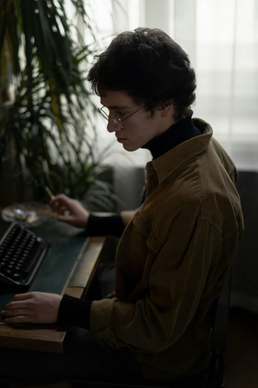a man sitting at a desk using a computer, an album cover, inspired by Elsa Bleda, trending on pexels, portrait androgynous girl, dark academia aesthetic, standing, wearing turtleneck