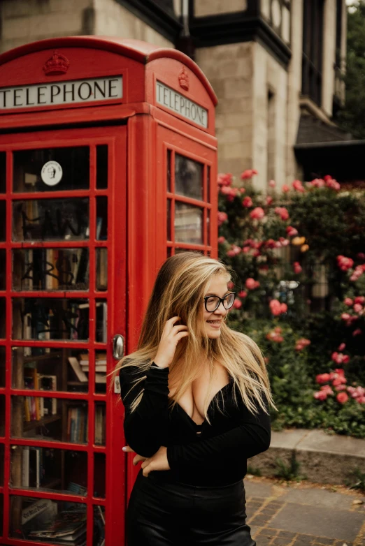 a woman standing in front of a red phone booth, a picture, pexels contest winner, she wears harry potter glasses, lush surroundings, beautiful blonde girl, thicc