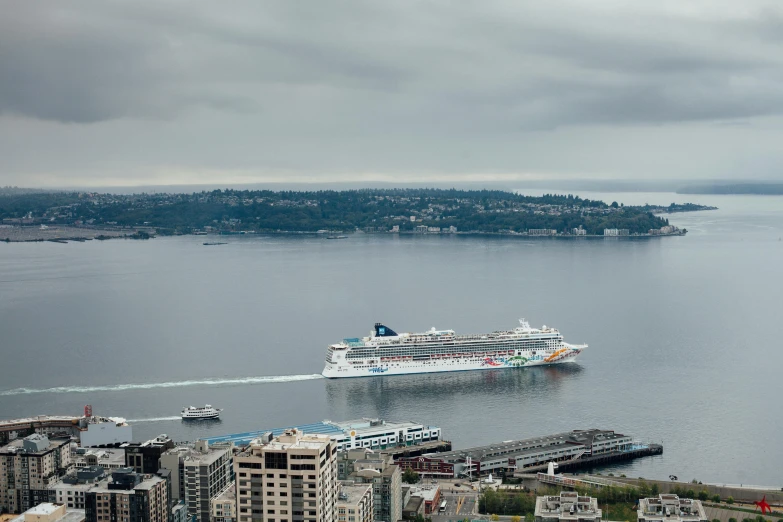 a large cruise ship traveling across a large body of water, by Doug Ohlson, pexels contest winner, seattle, view from helicopter, slight overcast, carnival