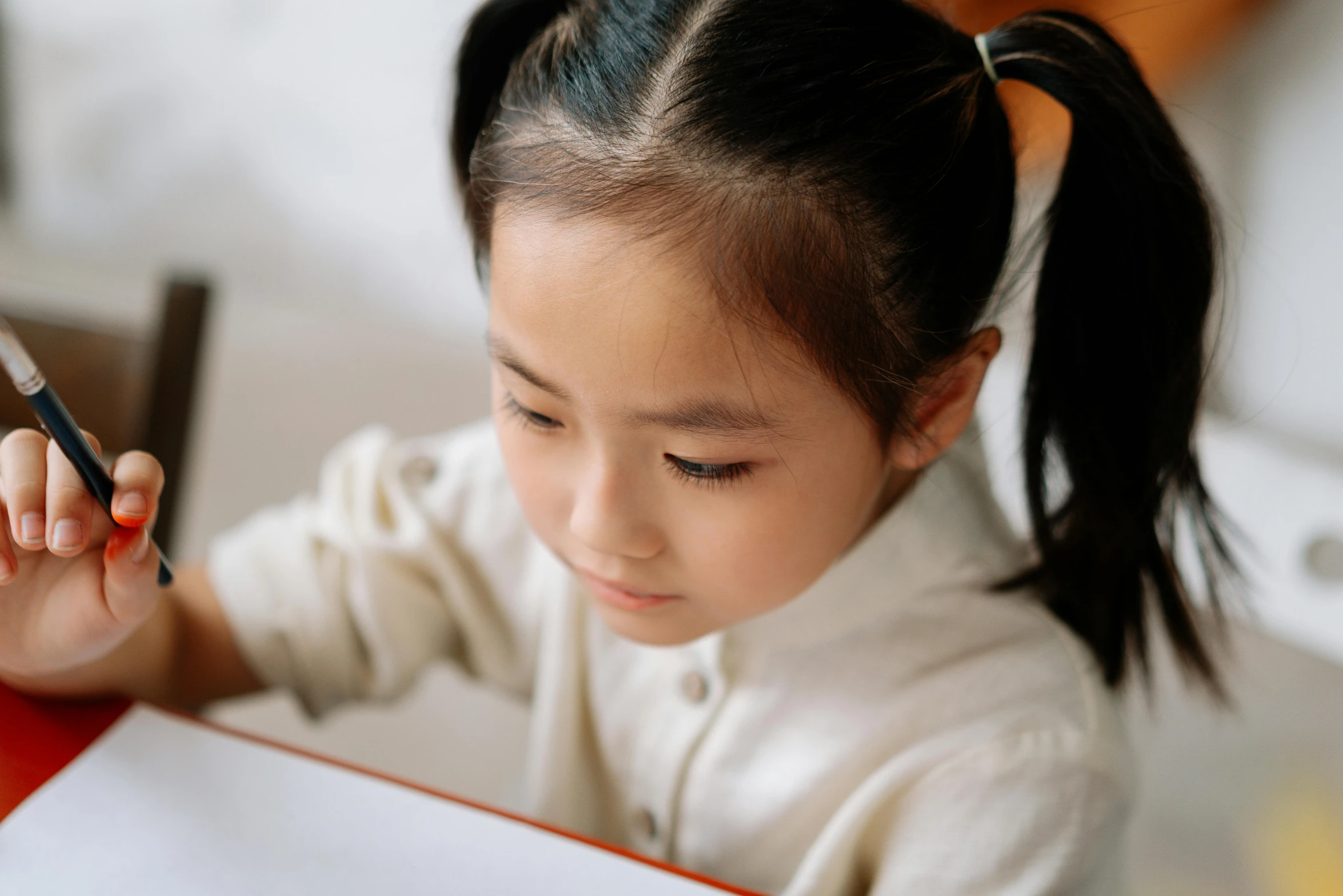 a little girl sitting at a table with a cell phone in her hand, a child's drawing, pexels contest winner, reading a book, asian face, typing on laptop, gif