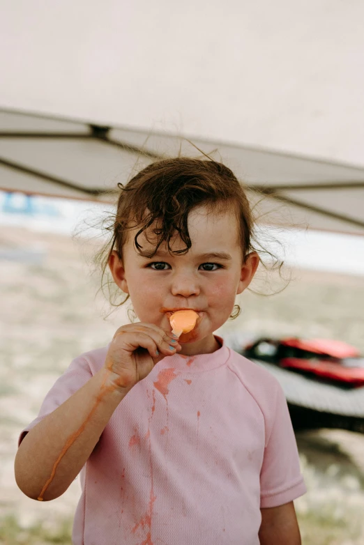 a little girl standing under a tent eating a carrot, pexels contest winner, red birthmark, dessert, lachlan bailey, mouth slightly open