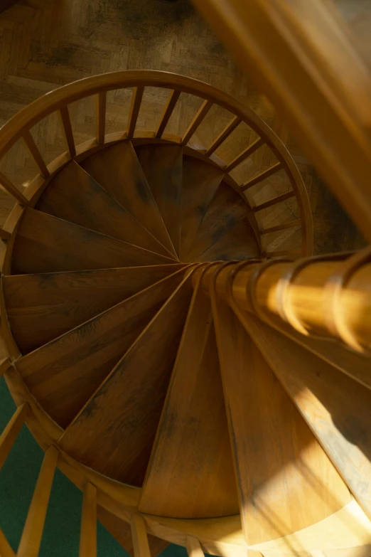 a spiral staircase going up the side of a building, by David Simpson, unsplash, renaissance, interior wood, b - roll, close-up from above, summer light