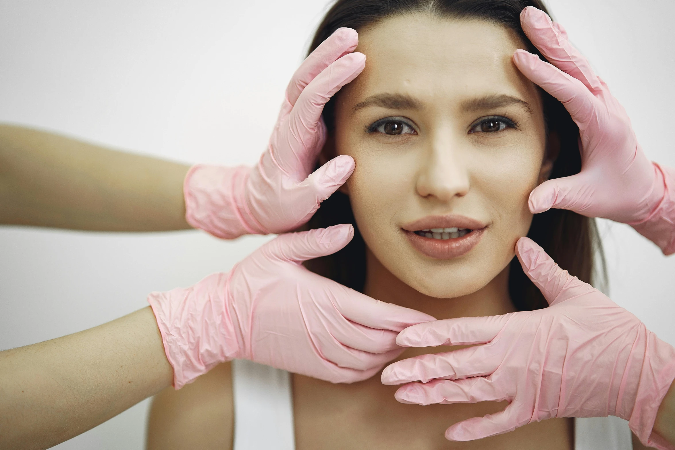 a woman with pink gloves covering her face, a portrait, trending on pexels, renaissance, surgical impliments, square facial structure, woman holding another woman, anaesthetic