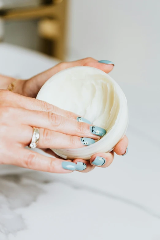 a close up of a person holding a bowl, neat nails, sea foam, detailed product shot, yogurt
