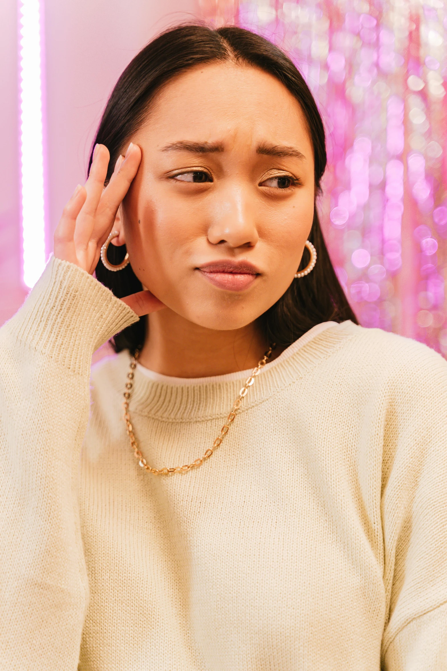 a woman holding a cell phone to her ear, by Julia Pishtar, gold chain necklace, wearing a sweater, south east asian with round face, disappointed