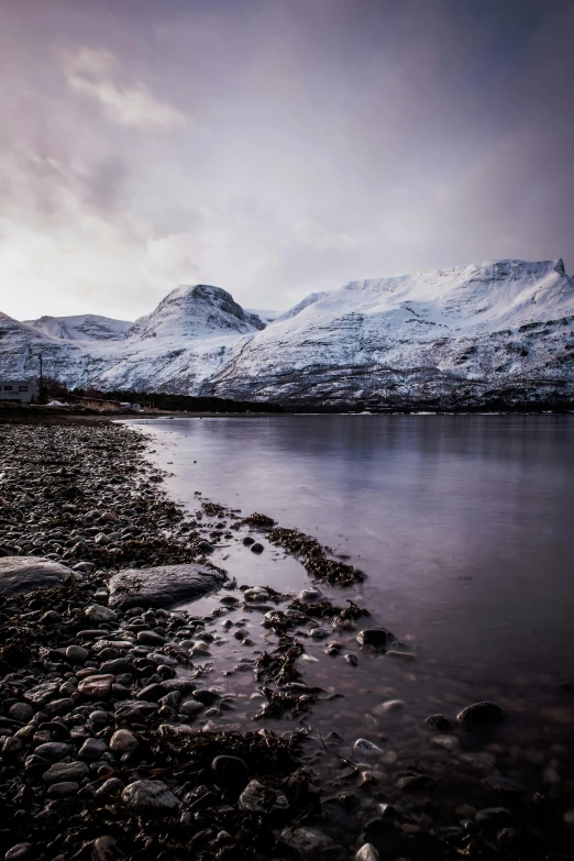 a body of water surrounded by snow covered mountains, a photo, inspired by Johan Christian Dahl, shore, fujifilm”