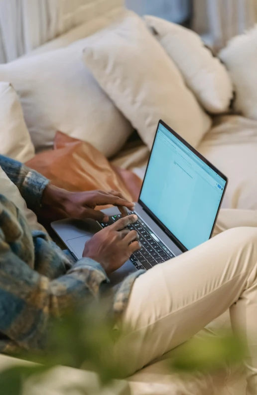 a man sitting on a couch using a laptop computer, by Carey Morris, pexels, bottom angle, riyahd cassiem, natural light outside, thumbnail