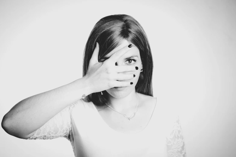 a woman covering her face with her hands, a black and white photo, photoshooting, with big eyes, hand gesture, uploaded