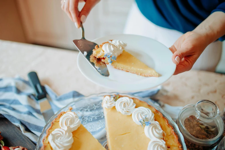 a person cutting a piece of pie on a plate, a pastel, by Carey Morris, pexels contest winner, yellow, holiday, creamy, blending