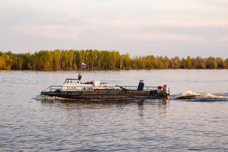 a boat on a body of water with trees in the background, a portrait, by Ilya Ostroukhov, flickr, hurufiyya, bioremediation, corporate photo, spring evening, trireme