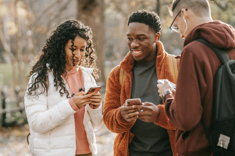 a group of young people standing next to each other, trending on pexels, happening, looking at his phone, brown, avatar image, wholesome