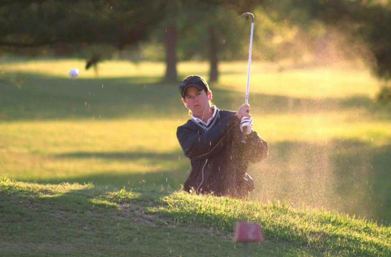 a man hitting a golf ball out of a bunker, by David Simpson, flickr, realism, nice afternoon lighting, high school, taken in the late 2000s, photo pinterest