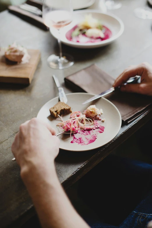 a person sitting at a table with a plate of food, unsplash, process art, plate of borscht, pink, chefs table, dwell