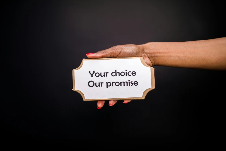 a woman's hand holding a sign that says your choice our promise, pexels contest winner, renaissance, orisha, product shoot, profile picture, multi-part