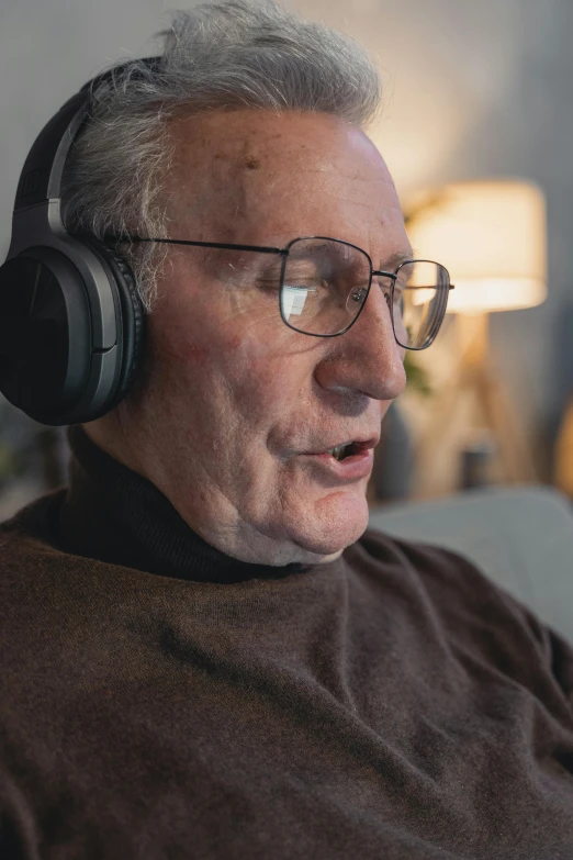 a man sitting on a couch wearing headphones, of an old man, uploaded, wholesome, close up to the screen