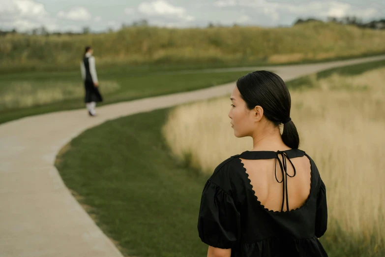 a woman in a black dress walking down a path, inspired by Wang Lü, pexels contest winner, renaissance, hammershøi, with a park in the background, prairie, sangsoo jeong