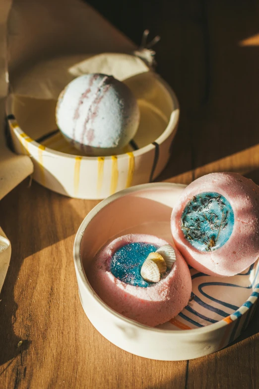 a couple of bowls of food sitting on top of a wooden table, pink and blue, where the planets are candy, bathhouse, artisanal art