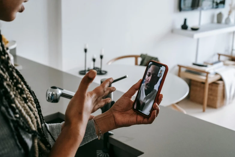 a woman taking a picture of herself on her phone, trending on pexels, hyperrealism, on kitchen table, a telephone receiver in hand, photo of a black woman, still from a live action movie