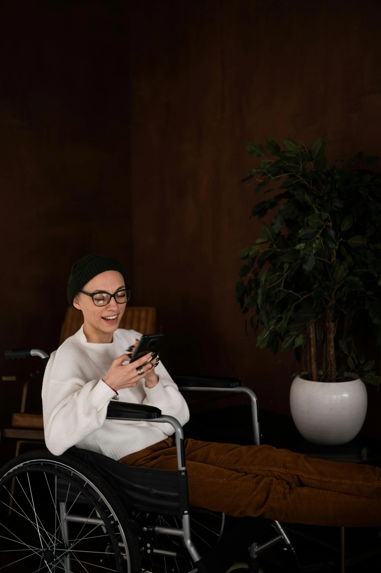 a woman in a wheelchair using a cell phone, a portrait, by Julia Pishtar, trending on pexels, hurufiyya, sitting on a mocha-colored table, 15081959 21121991 01012000 4k, designed for cozy aesthetics!, digital medical equipment