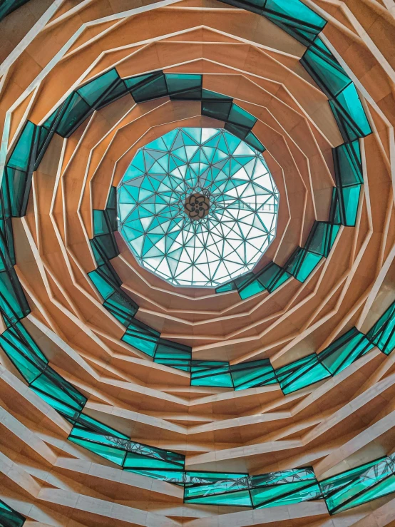 the inside of a building with a circular window, inspired by Buckminster Fuller, pexels contest winner, orange and teal color, high detail spiral design, futuristic marrakech morocco, viewed from below