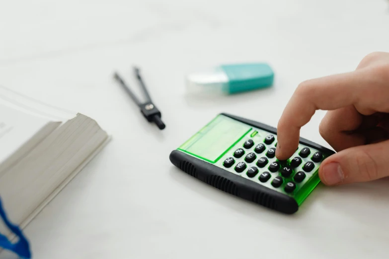 a person using a calculator on a table, a still life, inspired by Benjamin Franklin, trending on pexels, green: 0.25, synthetic materials, schools, asset on grey background