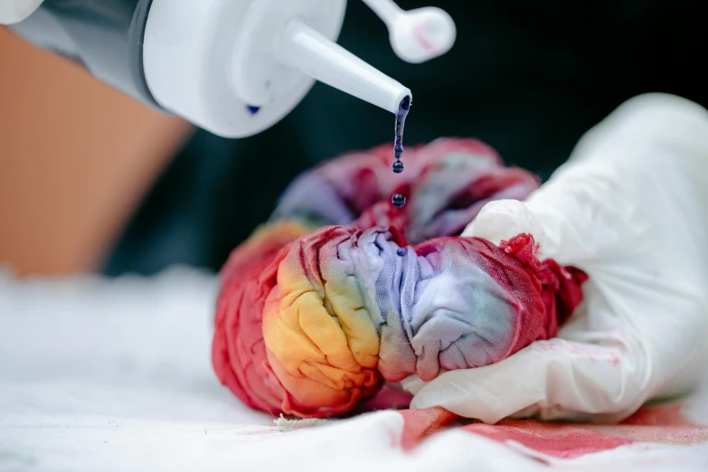 a close up of a person putting dye on a piece of cloth, trending on pexels, anatomical heart, brainbow, made of lab tissue, large brain in a vat