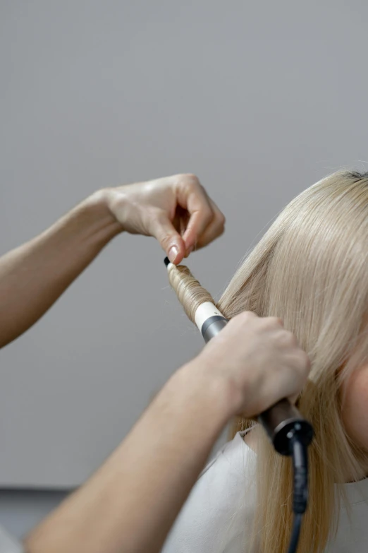 a woman blow drying another woman's hair, by Matthias Stom, trending on pexels, holding a thick staff, wavy blond hair, layer upon layer, video still