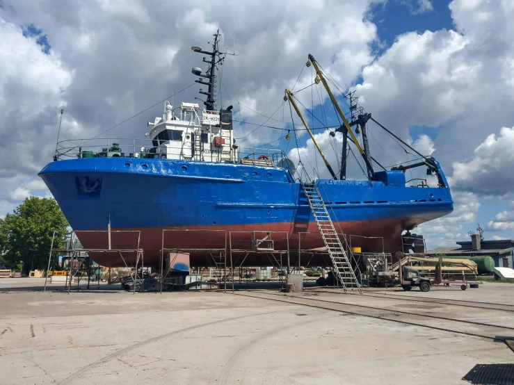 a large blue boat sitting on top of a dry dock, tx, maintenance photo, avatar image, fan favorite