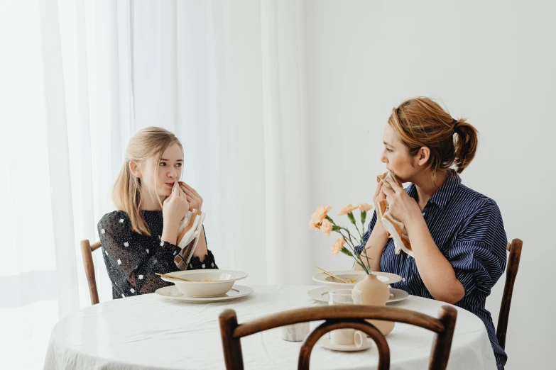 a woman and a little girl sitting at a table, sydney sweeney, soup, white bg, dining table