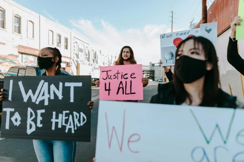 a group of people walking down a street holding signs, a photo, by Julia Pishtar, trending on pexels, justice, essence, cardboard, 3 4 5 3 1