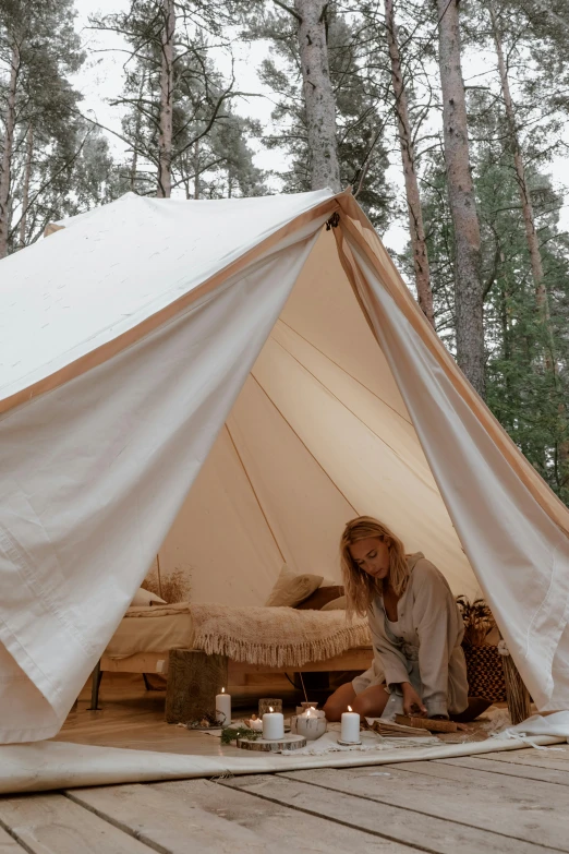 a woman sitting outside of a tent in the woods, unsplash, renaissance, finland, square, low quality photo, bedroom