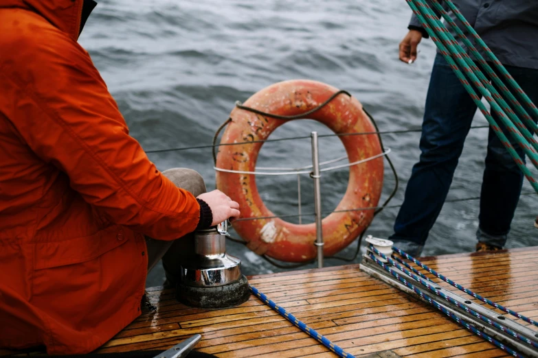 a person sitting on a boat with a life preserver, pexels contest winner, holding a bell, round about to start, low quality photo, lachlan bailey