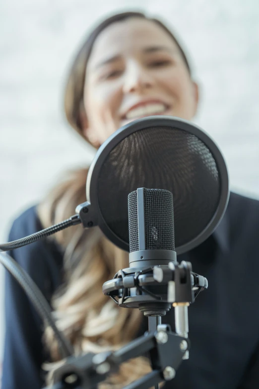 a woman sitting in front of a microphone, soft volume absorbation, zoomed in, promo image, standup