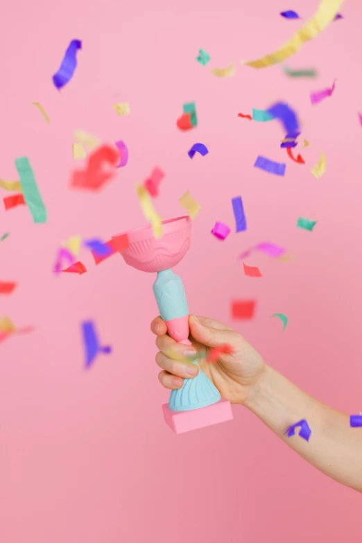a woman is throwing confetti in the air, an abstract sculpture, by Julia Pishtar, on a candle holder, bubblegum pop, pastel color theme, product introduction photo
