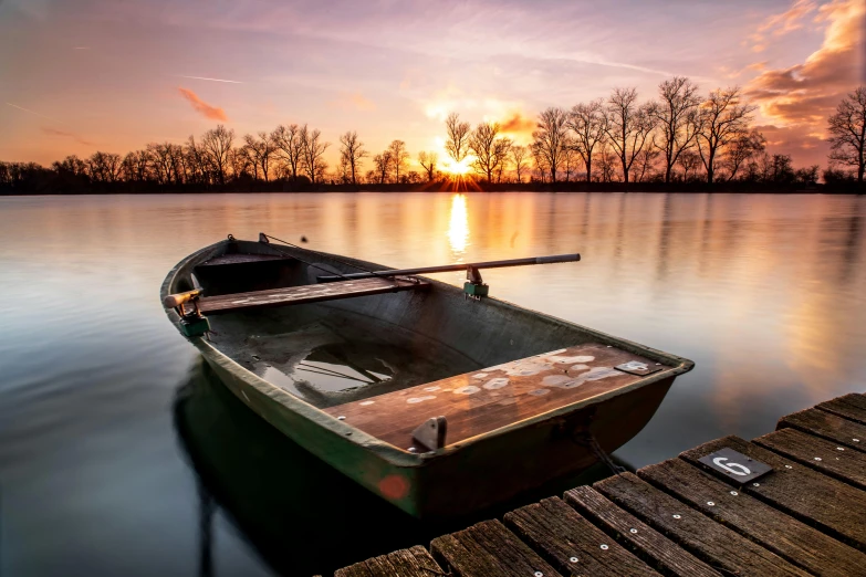 a small boat sitting on top of a body of water, by Antoni Brodowski, pexels contest winner, romanticism, sunset warm spring, winter lake setting, bucklebury ferry, today\'s featured photograph 4k