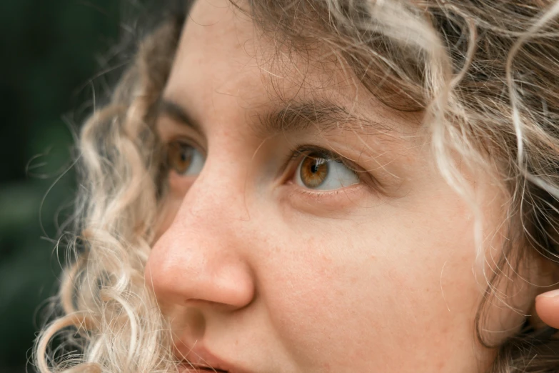 a close up of a person talking on a cell phone, by Carey Morris, trending on pexels, photorealism, curly blonde hair | d & d, staring eyes, color photograph portrait 4k, round nose