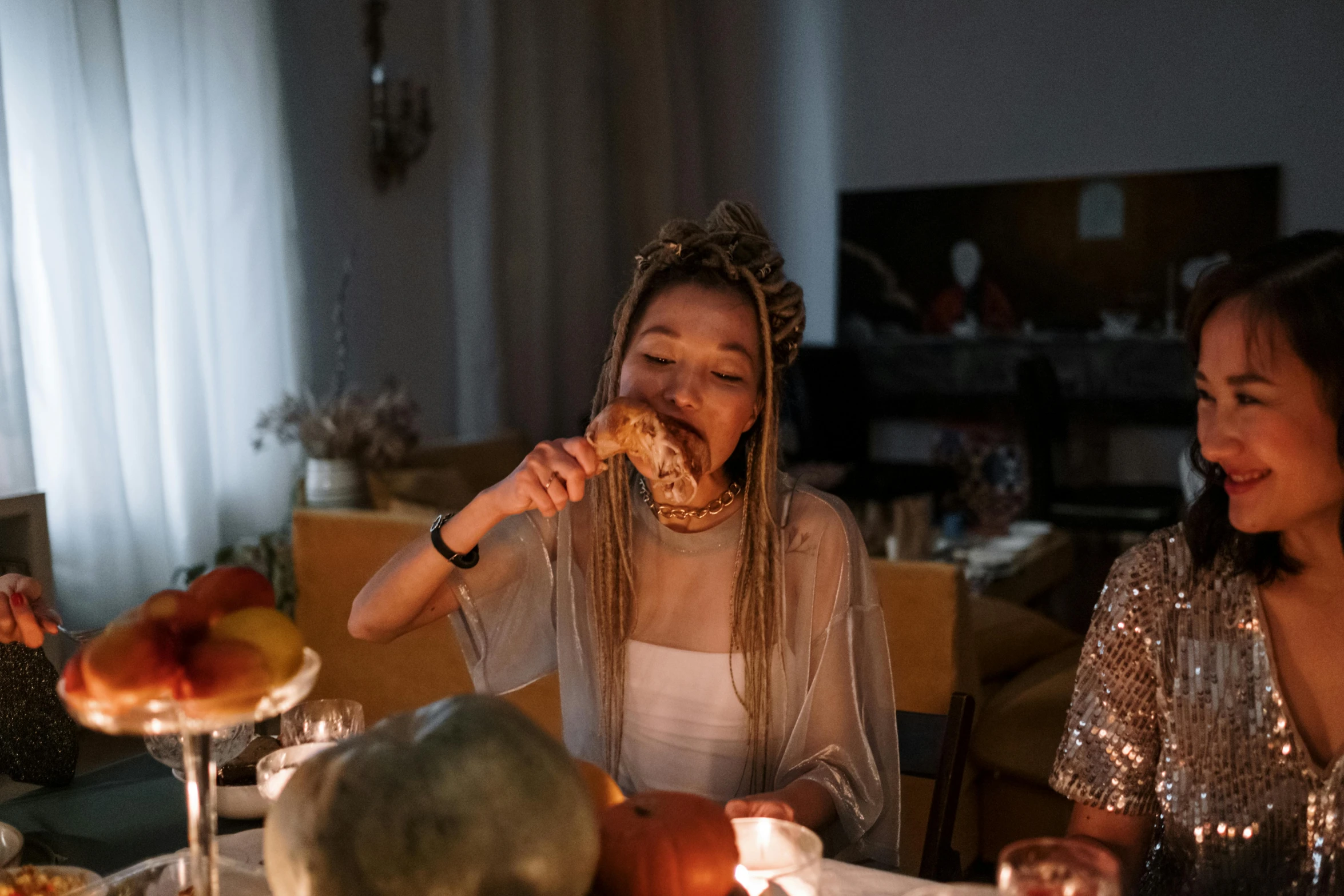 a couple of women sitting at a table eating food, by Julia Pishtar, pexels contest winner, halloween night, young girl playing flute, eating garlic bread, with a gold crown