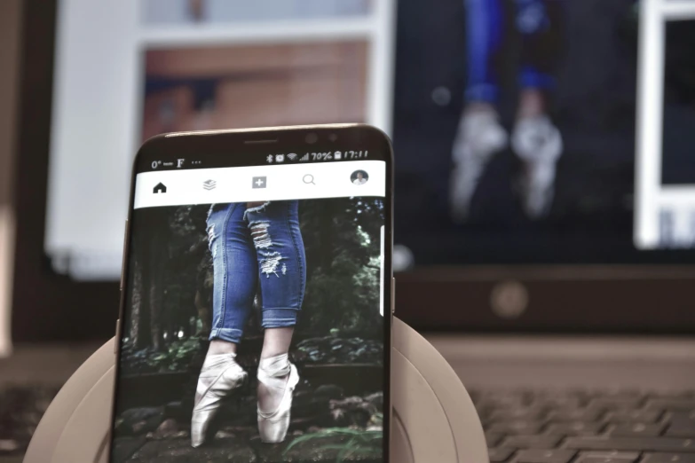 a close up of a cell phone in front of a laptop, a picture, by Android Jones, trending on pexels, happening, wearing a camisole and boots, avatar image, ballet style pose, 3d parallax view effect