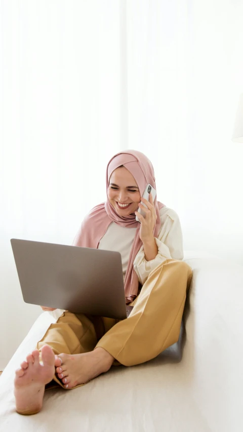 a woman sitting on the floor using a laptop, inspired by JoWOnder, shutterstock, hurufiyya, low quality photo, talking, beige, emir