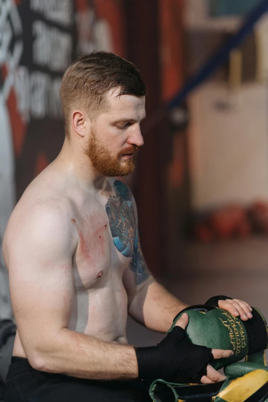 a man that is sitting down with a ball, a tattoo, inspired by William Conor, reddit, happening, hbo showtime boxing, hr ginger, 2019 trending photo, chest