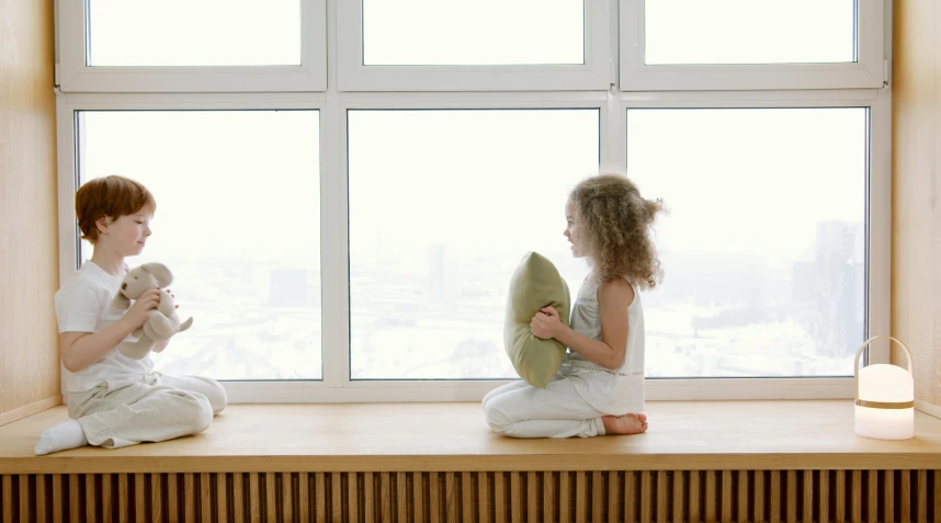 a couple of kids sitting on top of a window sill, pillows, 15081959 21121991 01012000 4k, throw pillows, ultrawide image