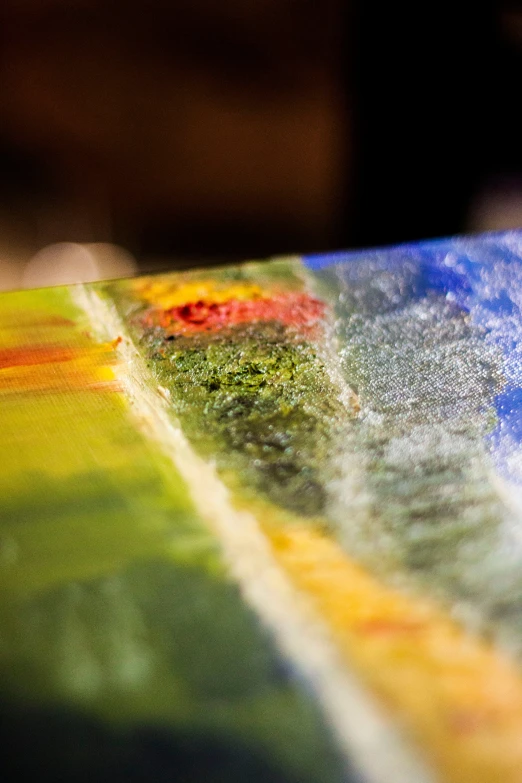 a close up of a surfboard on a table, inspired by Richter, flickr, abstract art, glass studio, blue and green and red tones, some yellow green and blue, made of wax and oil