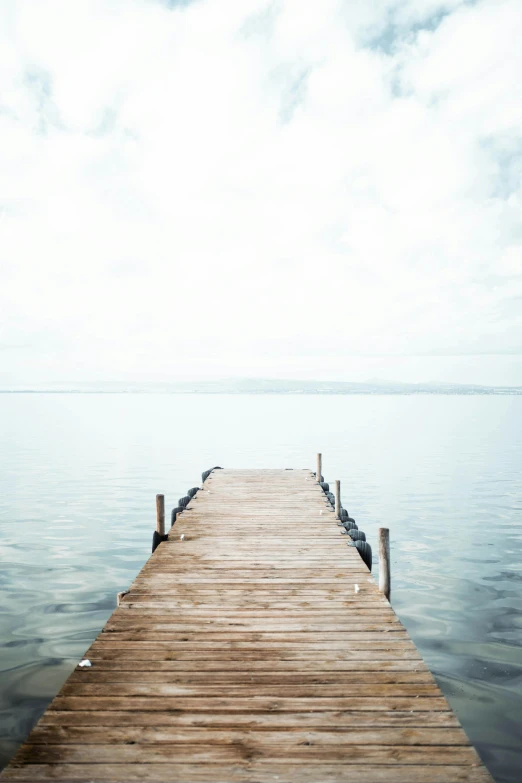 a wooden pier stretching out into the water, inspired by Georg Friedrich Schmidt, unsplash, minimalism, 2 5 6 x 2 5 6 pixels, pale sky, ultrawide watercolor, eyes wide