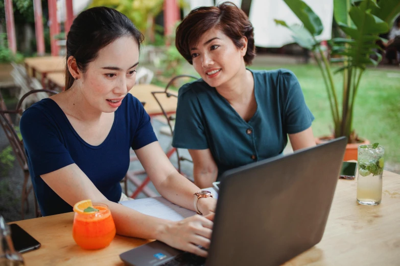 two women sitting at a table with a laptop, pexels contest winner, south east asian with long, avatar image, background image, nursing