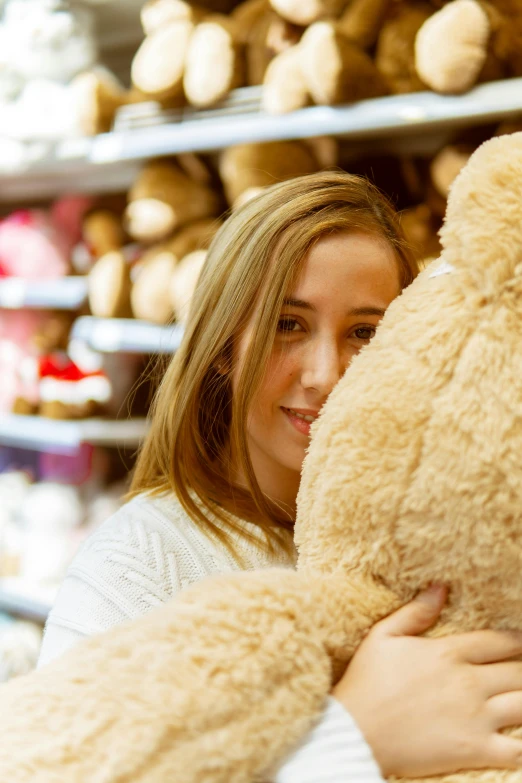 a woman holding a large teddy bear in a store, close together, engaging, aged 2 5, all around