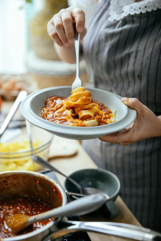 a close up of a person holding a plate of food, a picture, pasta, marmalade, cooking, easygoing